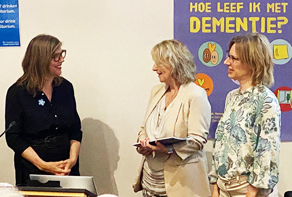 Anita Linskens biedt het boek aan aan Julie Meerveld (Alzheimer Nederland)